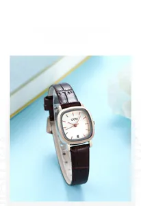 Close-up of square women's watch with brown leather strap and rose gold date display