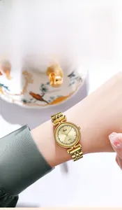 Elegant gold quartz watch with champagne sunray dial worn on wrist in a refined setting