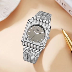 Elegant silver square watch with grey dial and metal mesh strap in a lifestyle setting