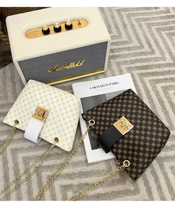 Detail of vintage monogram chain bucket bags in white and brown with gold hardware
