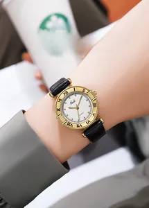 Close-up of vintage quartz watch with gold case, roman numerals and black leather strap