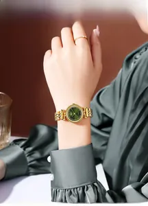 Close-up of Gedi gold steel watch with green sunray dial and matching ring on wrist