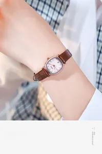 Close-up of elegant square rose gold watch with brown crocodile leather strap on wrist