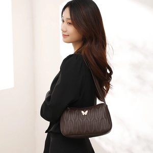 Deep brown quilted PU underarm bag with gold butterfly hardware shown on model