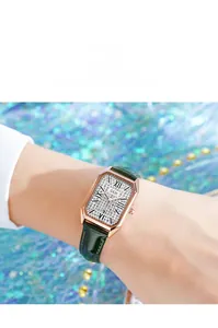 Close-up of luxury women's rectangular watch with full diamond dial and green leather strap