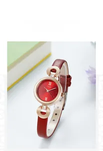 Gros plan du cadran rouge à chiffres romains et bracelet fin en cuir pour cette montre
