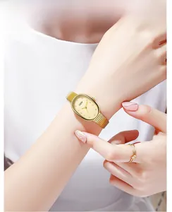 Gros plan d'une élégante montre ovale dorée avec cadran en nacre et bracelet en maille