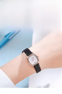 Close-up of elegant square gold watch with white dial and black leather strap