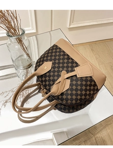Detailed view of vintage printed shell handbag with brown monogram and gold hardware