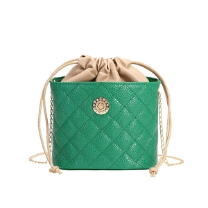 Green quilted bucket bag with beige drawstring insert and gold chain shoulder strap