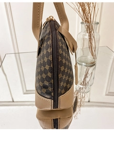 Detail of vintage clover print handbag showing stitching and gold zipper hardware