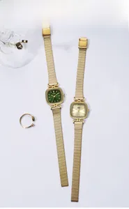 Détail de deux montres à quartz carrées avec bracelets en chaîne de serpent dorée chic