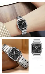 Vue macro d'une montre carrée argentée avec cadran noir texturé et bracelet en acier