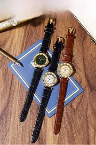 Three vintage quartz watches with roman numeral bezels on a dark wooden background