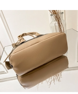 Low angle view of beige printed handbag showing wide base structure and fine stitching