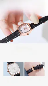 Detail of a square rose gold watch with a black leather band and stainless steel back cover