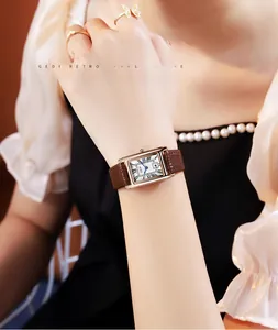 Close-up of vintage square quartz watch with brown leather strap and Roman numerals