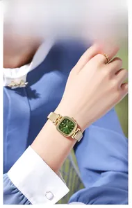 Gros plan d'une montre femme GEDI dorée avec cadran vert et bague assortie