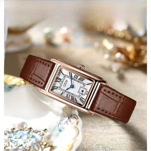 Macro detail of square vintage watch featuring a rose gold case and brown leather strap