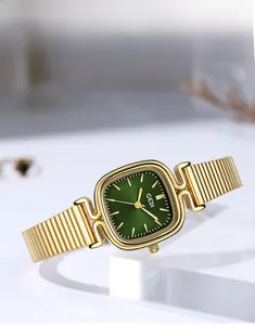 Détail de montre carrée dorée avec cadran vert forêt et bracelet en maille fine