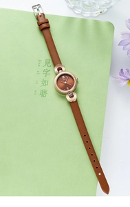 Détails d'une montre à quartz pour femme avec bracelet en cuir marron et boîtier doré rose
