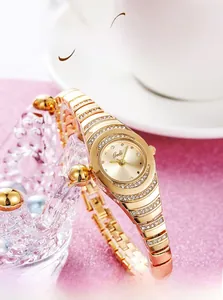 Detailed close-up of a gold ladies' bracelet watch with rhinestones on a crown stand