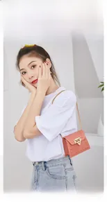 Detail of coral pink PVC rivet jelly bag featuring gold chain and heart shaped lock buckle