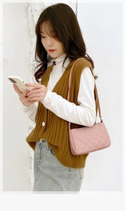 Detail of pink quilted shoulder bag with rhombus stitching and slim leather strap