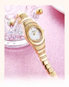 Macro detail of golden bracelet watch featuring rhinestone bezel and mother-of-pearl dial