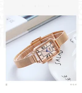 Détail de montre rectangulaire or rose avec cadran champagne et bracelet maille