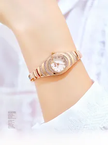 Close-up of luxury gold-toned quartz bracelet watch with crystal bezel on model wrist