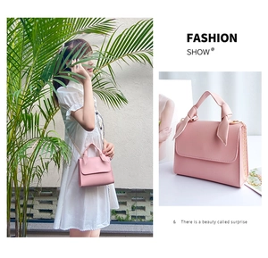 Pink lychee leather mini handbag with ribbon-wrapped handle and gold chain strap detail