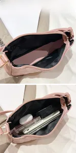 Detail of pink quilted bag interior showing black lining and capacity for cosmetics