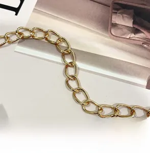 Close-up of a golden polished metal chain strap for a ladies embroidered quilted bag