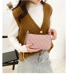Detail of light pink quilted underarm bag with adjustable strap worn on shoulder