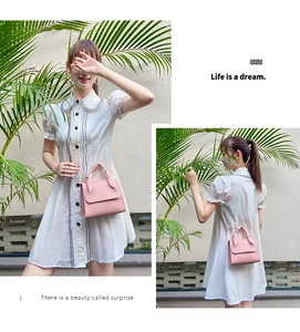 Detailed view of a pink small square bag with leather handle and bow metal chain strap