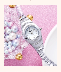 Close-up of silver quartz watch with rhinestone bezel on pink glitter background