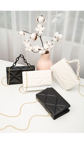 Quilted women's crossbody bags with gold chain straps and resin handles in black and cream