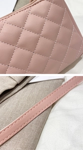 Close-up of pink quilted stitching on faux leather handbag with shoulder strap details