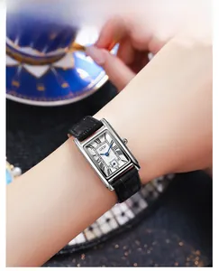 Close-up of vintage square watch with Roman numerals and blue hands on leather strap