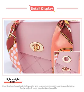 Detail view of pink leather bag with a gold twist lock and chain print silk scarf accent