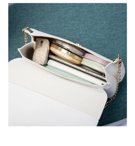 Internal view of a white PU leather crossbody bag showing chain strap and storage capacity