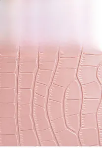 Gros plan sur la texture crocodile rose gaufrée de ce sac seau en cuir synthétique