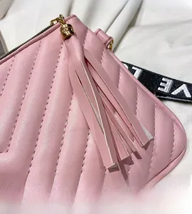 Macro di borsa trapuntata rosa con nappina lunga e dettaglio della cerniera dorata