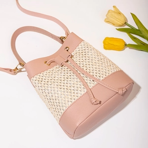 Pink faux leather and straw woven bucket bag with drawstring and golden hardware