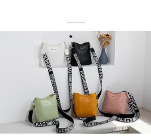Vue détaillée des sacs seaux motif crocodile en cinq couleurs avec bandoulières tissées