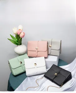 Detailed row of various colorful faux leather crossbody bags with gold metal chains