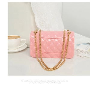 Détail du sac en gelée rose à losanges avec chaîne dorée et texture en PVC translucide