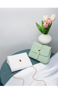 Detail of white and mint green chain crossbody bags on silk with tulips