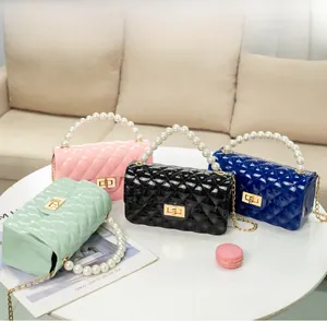 Multi-color PVC jelly bags with pearl handles and quilted texture in a cozy setting